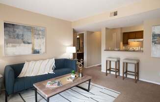 A living room with a blue couch and a coffee table.