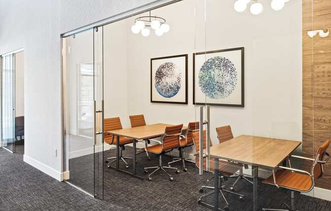 a conference room with tables and chairs and paintings on the wall at Aura Vegas Apartments, Las Vegas, 89103