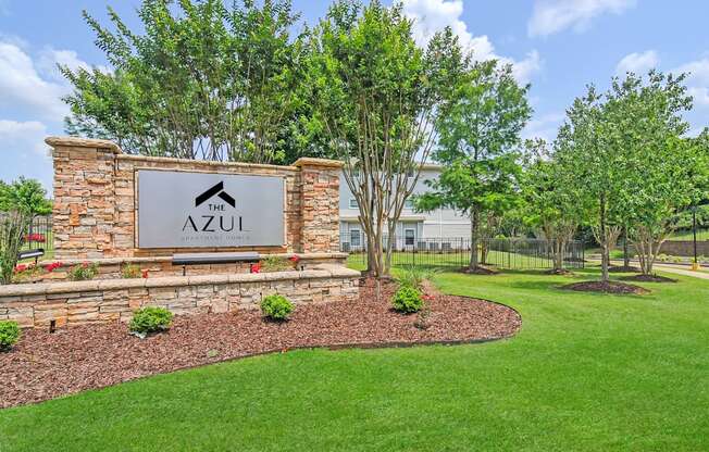 the apartments sign with green grass and trees
