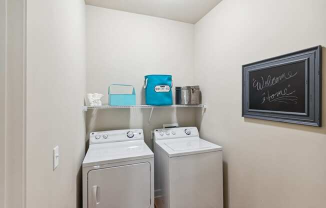 a washer and dryer in the laundry room at the enclave at woodbridge apartments in