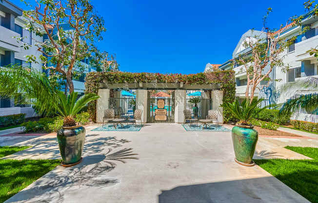 a courtyard with a building in the background and two large vases on the side of the