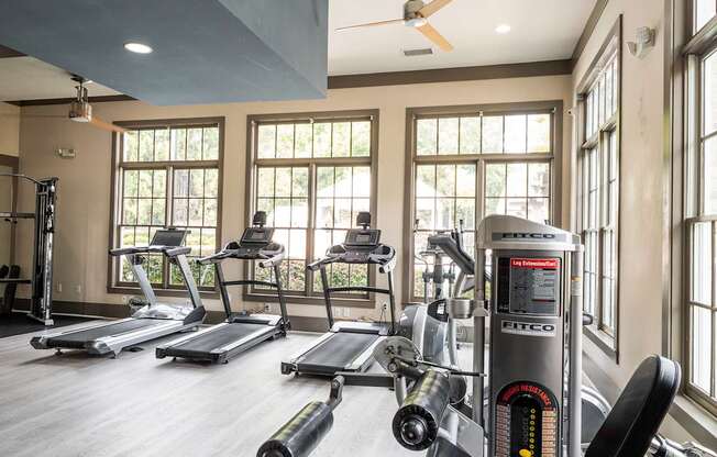 A gym with treadmills, elliptical machines, and a weight machine.
