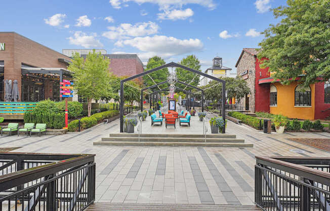 A walkway with a metal railing on both sides leads to a small building.