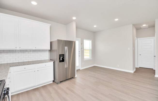 a kitchen with white cabinets and a stainless steel refrigerator