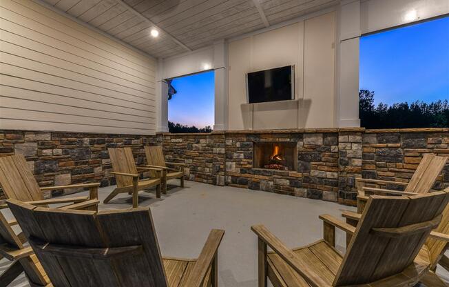 Cozy outdoor lounge with fireplace, TV, and ample seating at The Station at Brighton apartments for rent in Grovetown, GA
