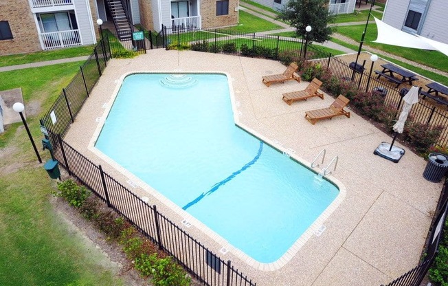 an aerial view of a swimming pool in front of an apartment building
