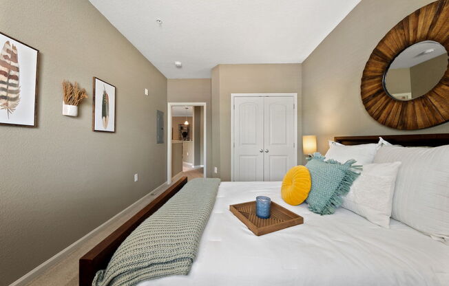 large bedroom with model furnishings, plush carpeting, and neutral paint colors