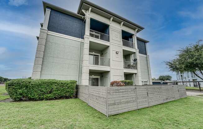 an apartment building with a wooden fence in front of it