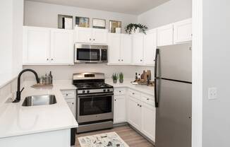 a kitchen with stainless steel appliances and white cabinets