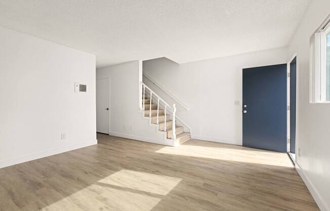 A room with a staircase leading to another room.