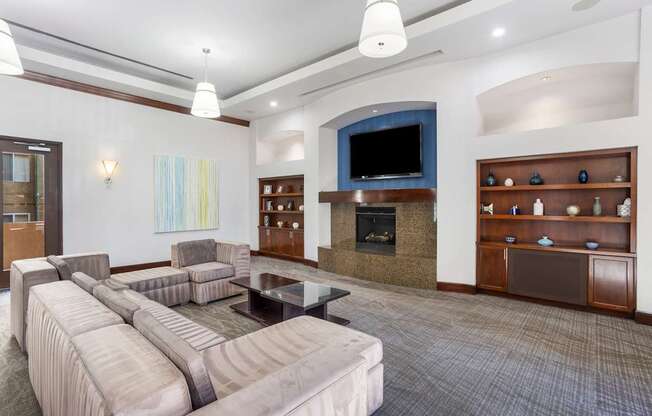 A living room with a grey couch and a television.
