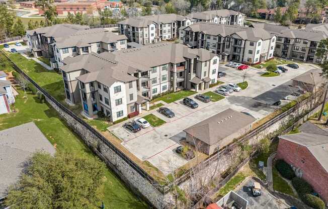 Apartment complex with a parking lot in front.