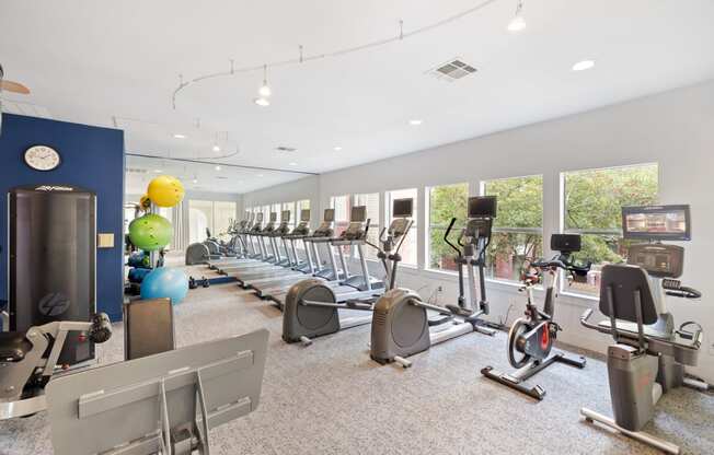 a spacious fitness center with cardio machines and weights