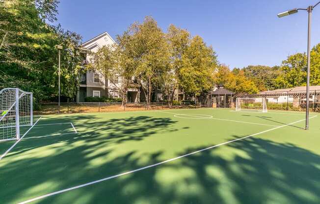 a tennis court with trees and a house in the background at Deerfield Village, Georgia