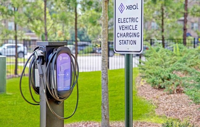 a purple electric vehicle charging station with a sign in the background