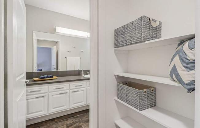 A bathroom with white cabinets and a mirror.
