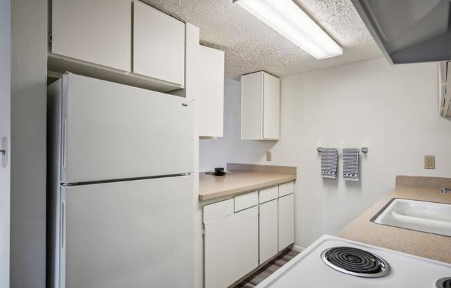 a kitchen with white appliances and a white refrigerator