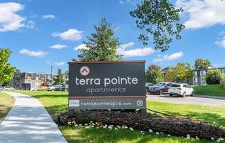 A sign for Terra Pointe Apartments is displayed in front of a building.