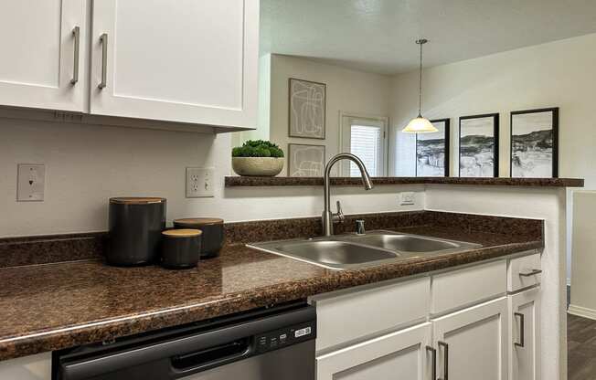 a kitchen with white cabinets and a sink and a counter top