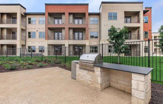 Apartment complex with a stone bench in front.