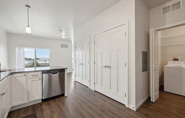 an empty kitchen with white cabinets and a white refrigerator and a sink