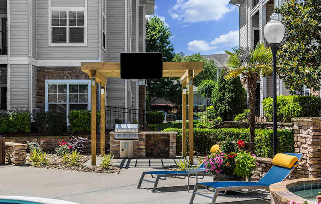 A poolside area with a TV and lounge chairs.