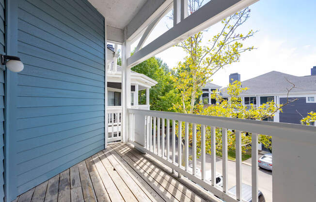 the view from the deck of a blue house with a white railing