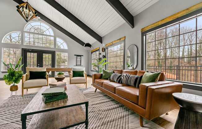 A living room with a brown leather couch and a wooden coffee table.