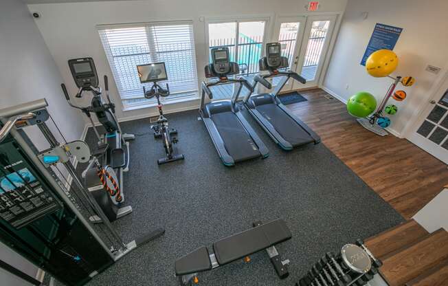 a gym with cardio equipment and weights in an apartment