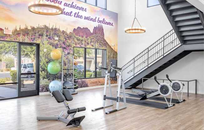 A gym with a staircase and exercise equipment.