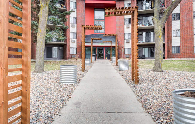 a walkway with a red brick building in the background