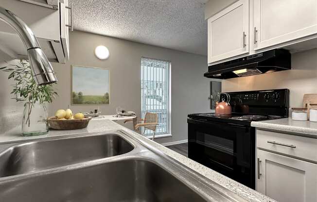 A modern kitchen with a stainless steel sink and black appliances.