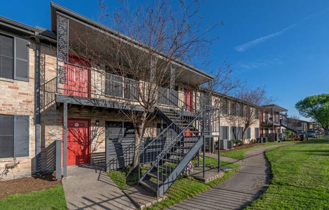 exterior photo of two story apartment building with stairs