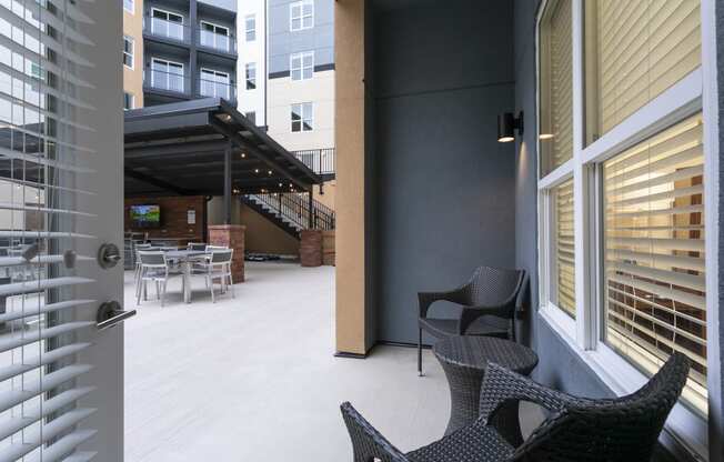 a patio with two chairs and a table in front of a door at Aster Apartments, Beachwood Ohio