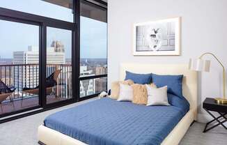 A bedroom with a large bed and a view of the city.