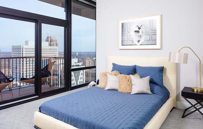 A bedroom with a large bed and a view of the city.