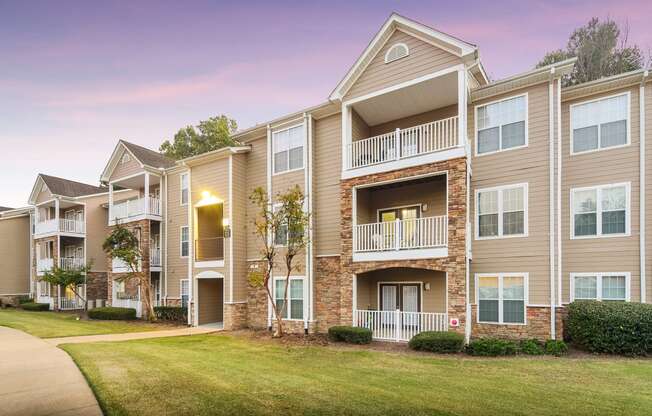 the outlook of a building at dusk with green grass at Highlands Apartment Homes, Bartlett, TN, 38135