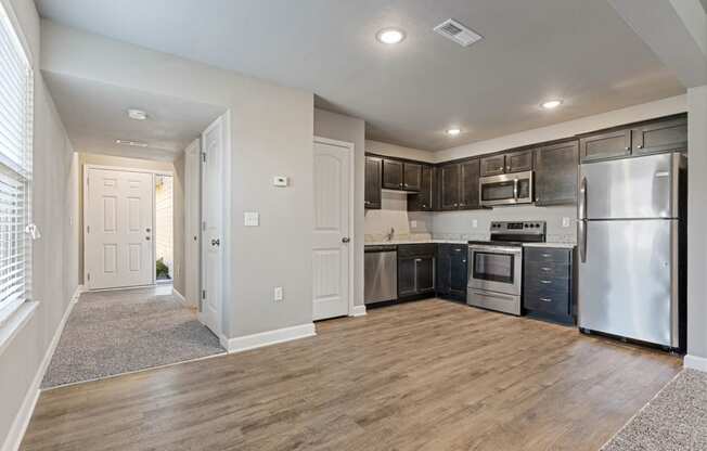 an empty kitchen and living room with stainless steel appliances