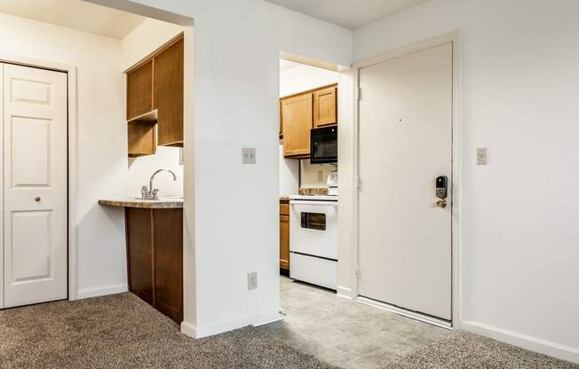an empty kitchen with a door to the living room at Pheasant Run in Lafayette, IN 47909