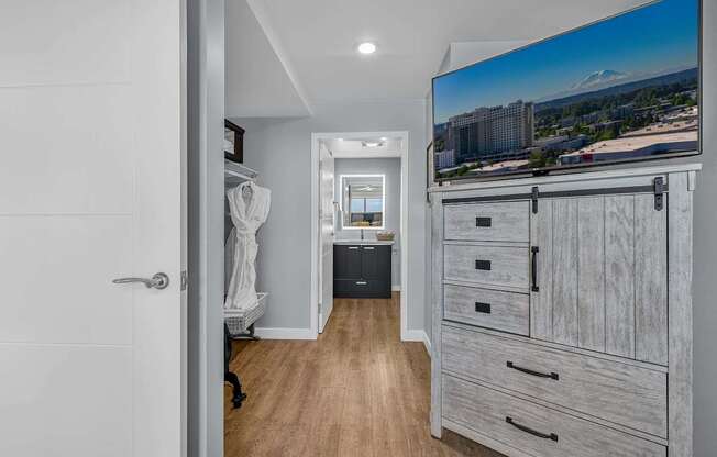A hallway with a statue, a TV, and a trash can.