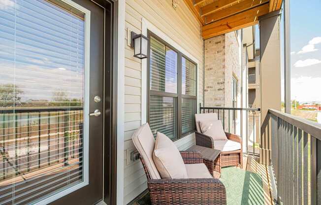 A balcony with a chair and a table.
