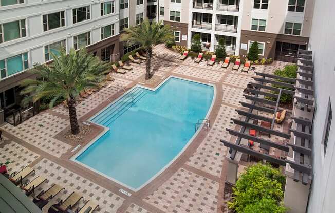 an overhead view of a swimming pool in front of an apartment building