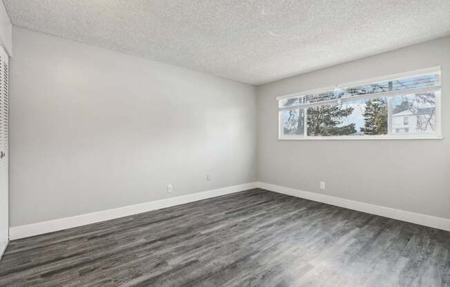 A room with a grey floor and a picture on the wall.