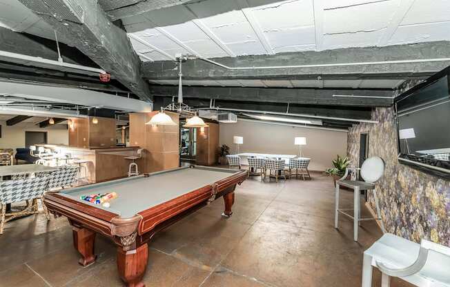 a game room with a pool table and tables