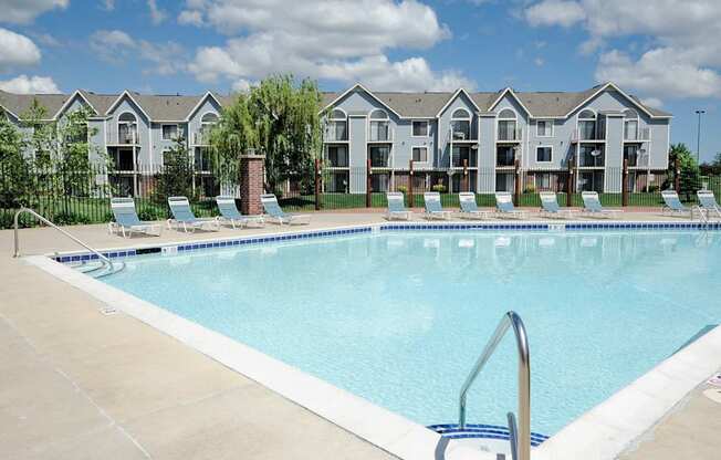 A swimming pool in front of apartment buildings.