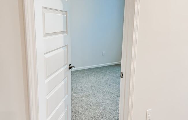 A room with a ceiling fan and a door.