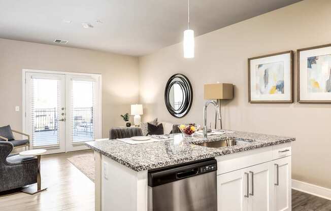 A modern kitchen with a granite countertop and a black dishwasher.