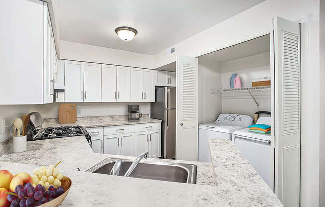 A kitchen with a hard-surface counter top and white cabinets at Brentwood Park Apartments in LaVista, NE