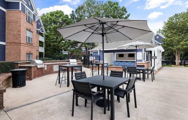 a patio with a table and chairs with umbrellas