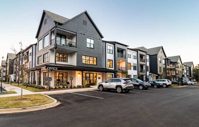 Huntsville, AL, Aparments Near Top Golf - The Collins - Exterior View Of The Leasing Office With Maintained Landscaping and Parked Vehicles